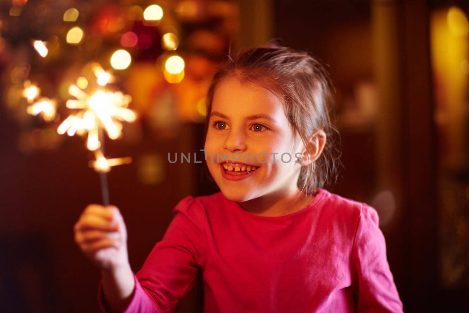 A happy little girl playing with a sparkler