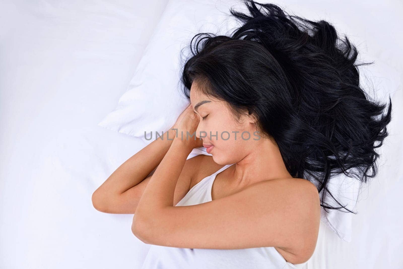 Young asian woman sleeping with head lying on hand in the bedroom