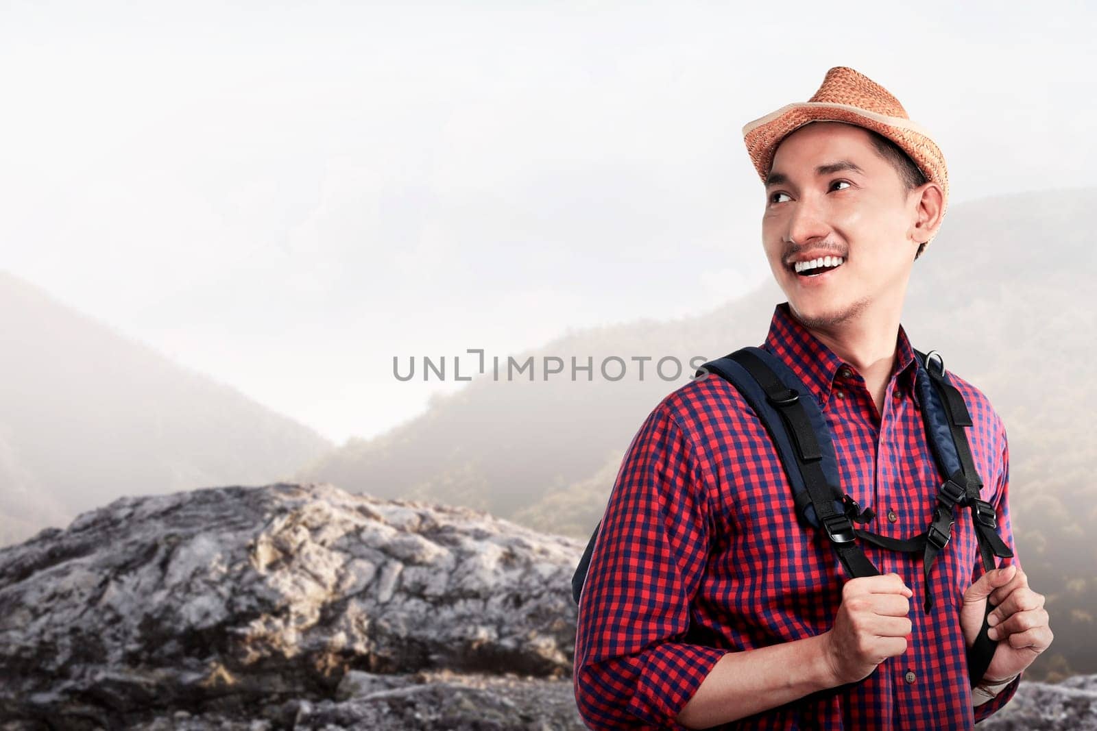 Young asian traveler smiling when hiking on the mountain