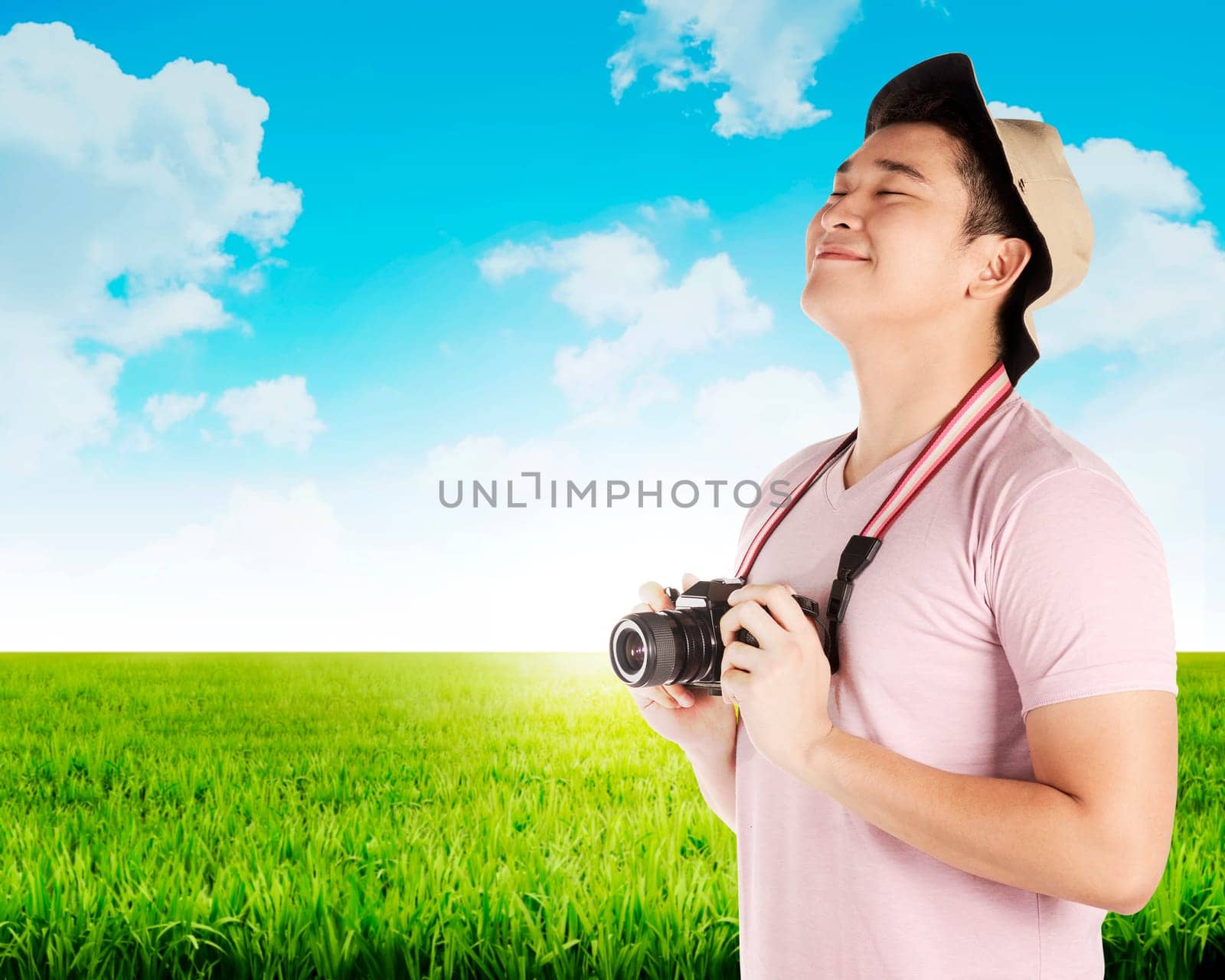 Asian tourist take photo on green meadow. Summer holiday concept