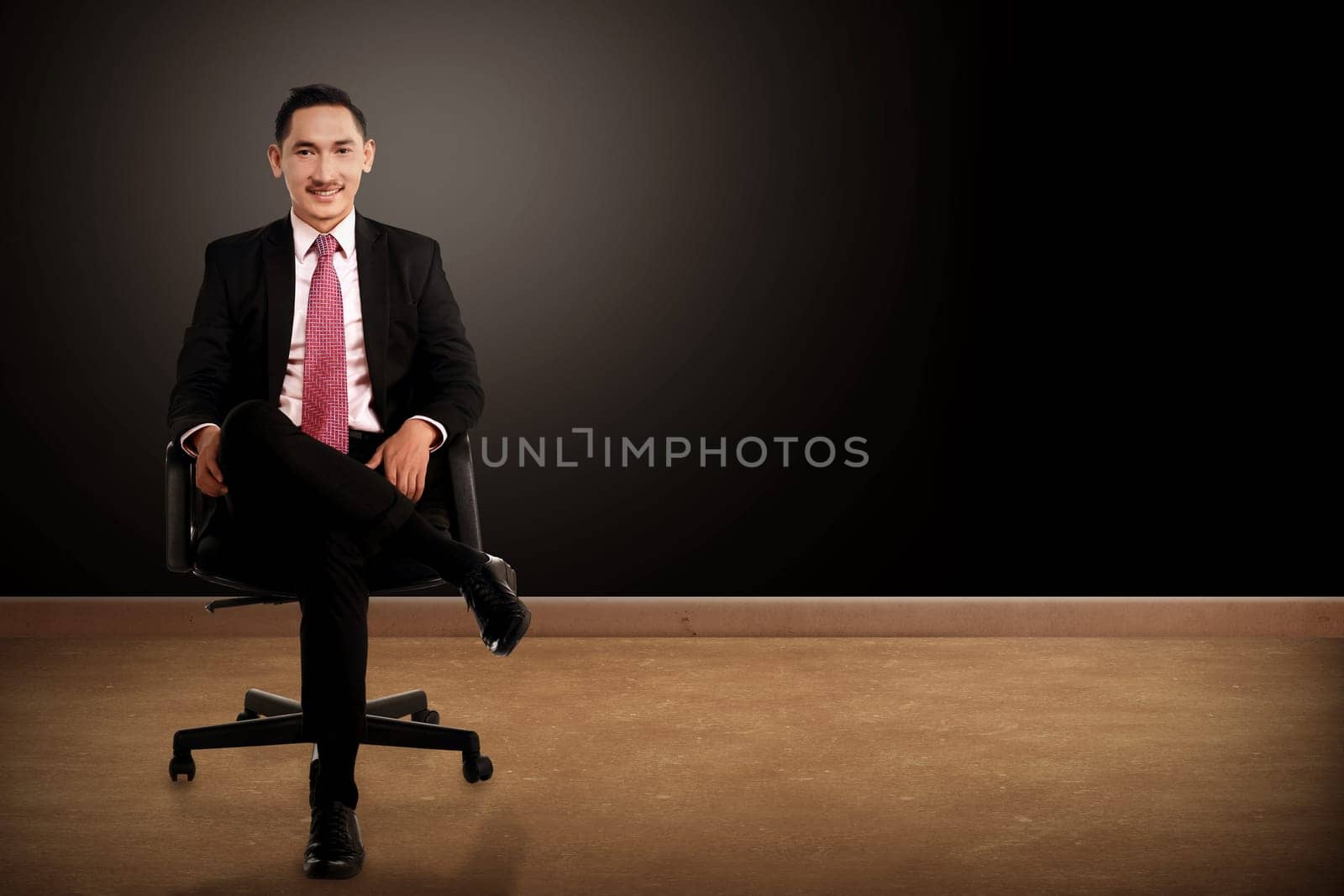 Business man sitting on the chair with black background