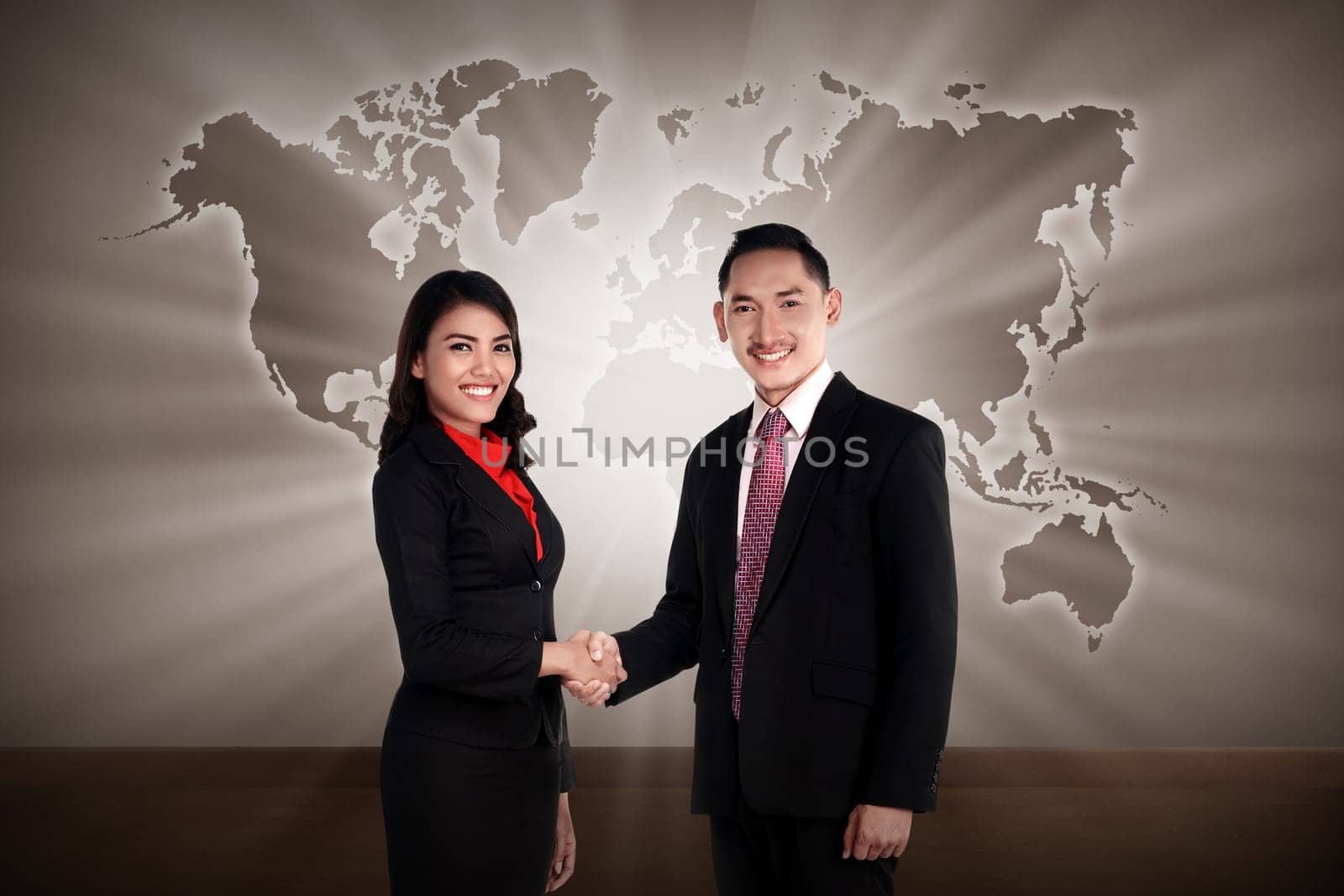 Man and woman shaking hand with world map as background