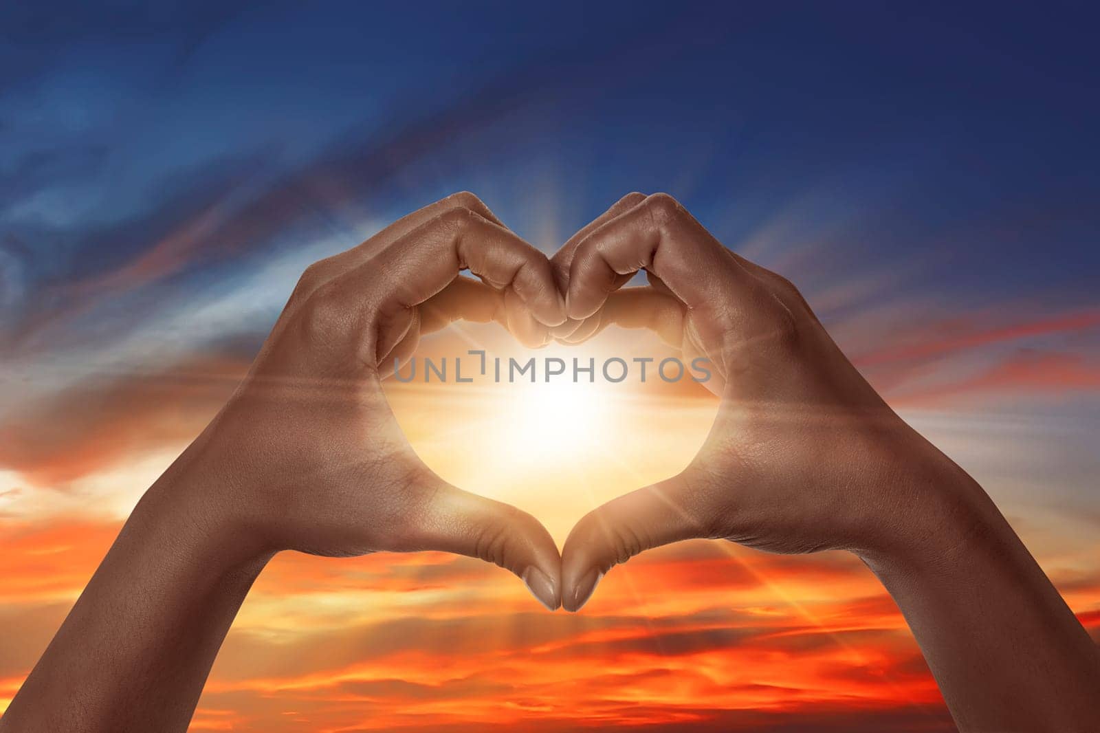 Heart shaped hand with sunrise background. heart shaped hand is a symbol of love, freedom, romance