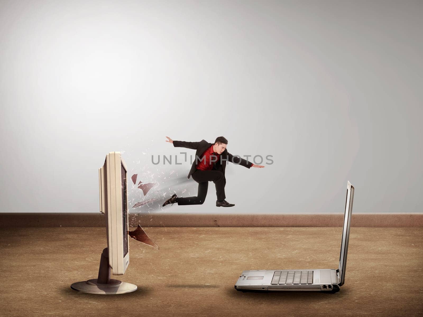 Business man jumping from desktop computer to laptop. Switch to mobile technology