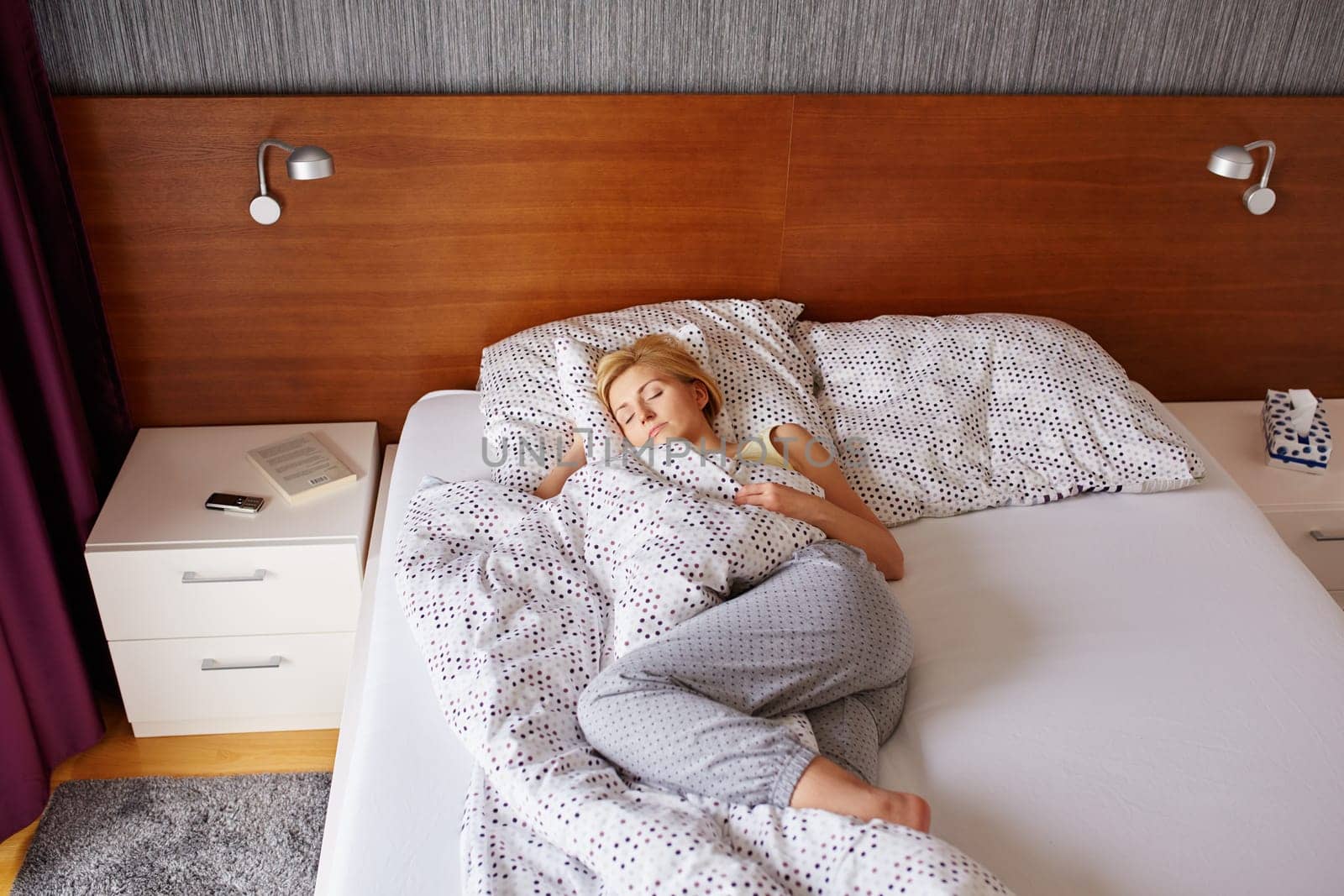 A young woman asleep in her bed