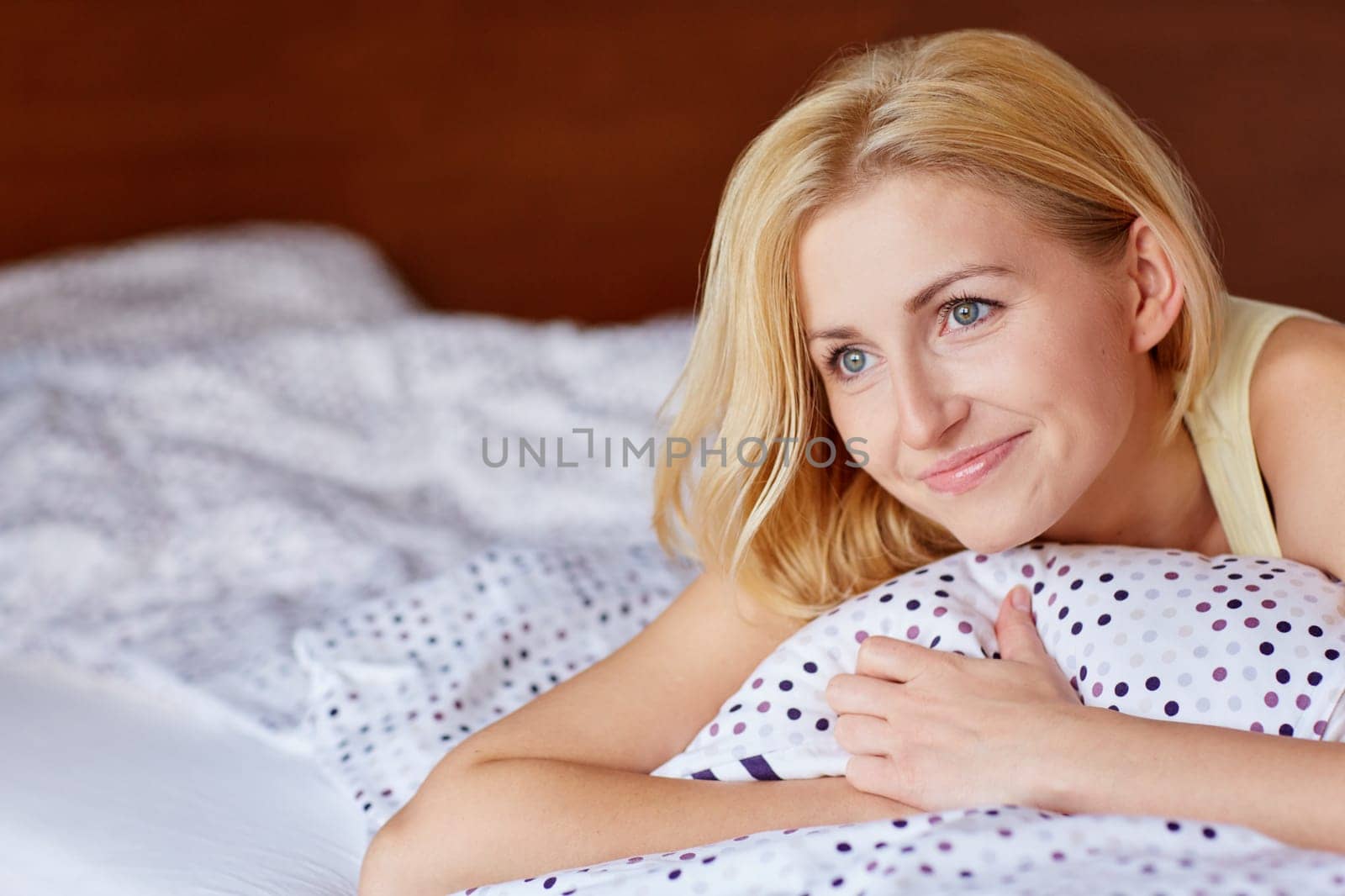 A happy young woman in bed shortly after waking