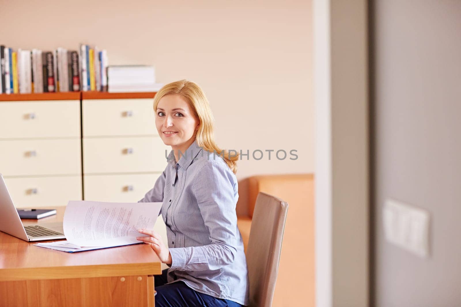 A businesswoman reading documents at her desk