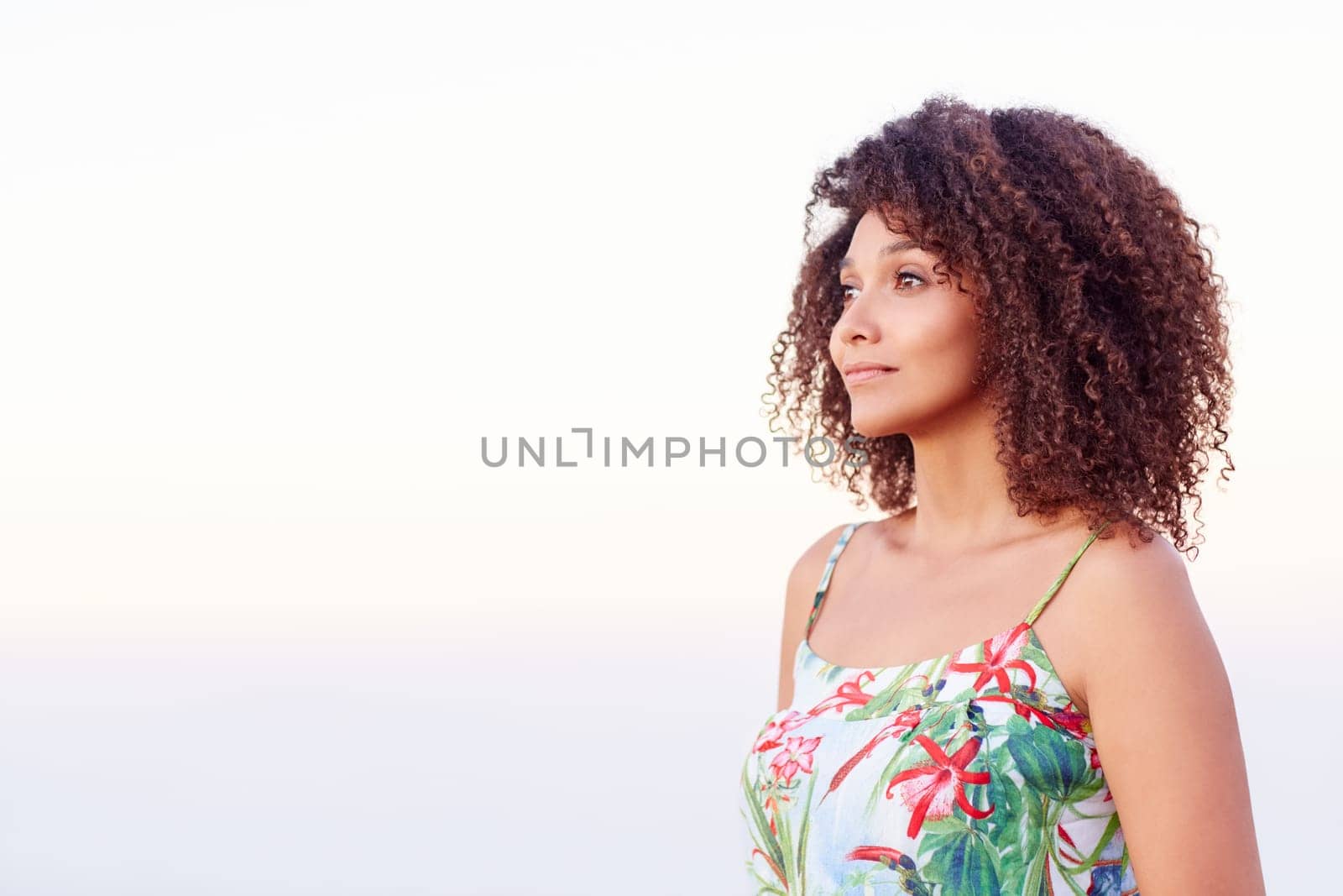 Confident mixed race woman with a serene expression looking away while standing outdoors