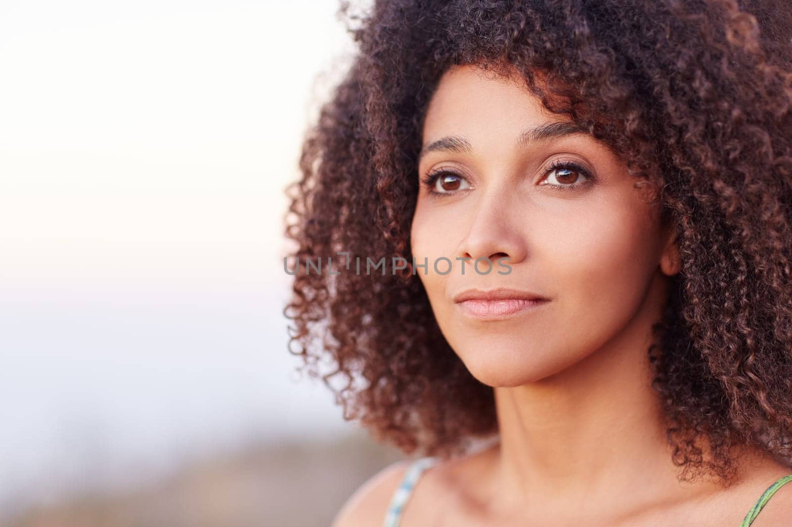 Intimate closeup portrait of a beautiful mixed race woman outdoors looking serenely into the distance