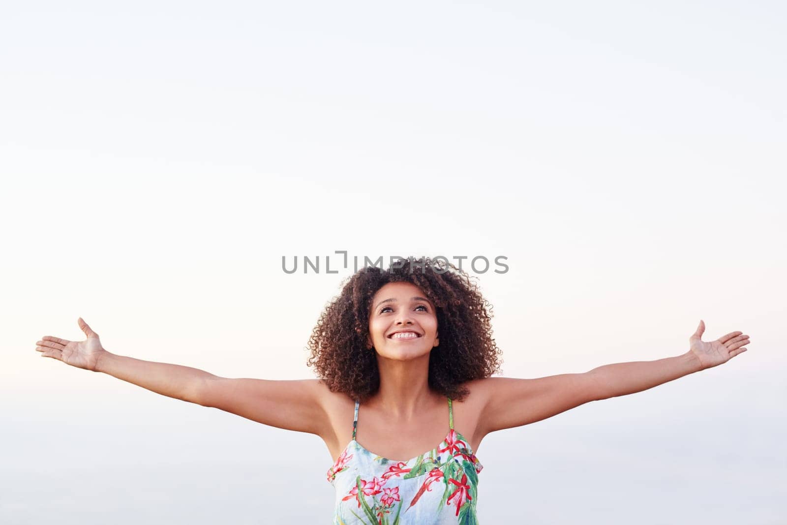 Happy mixed race woman with outstretched arms outdoors expressing freedom