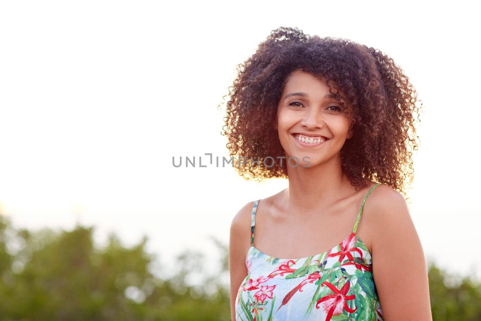 Portrait of a beautiful young mixed race woman smiling outdoors in a park