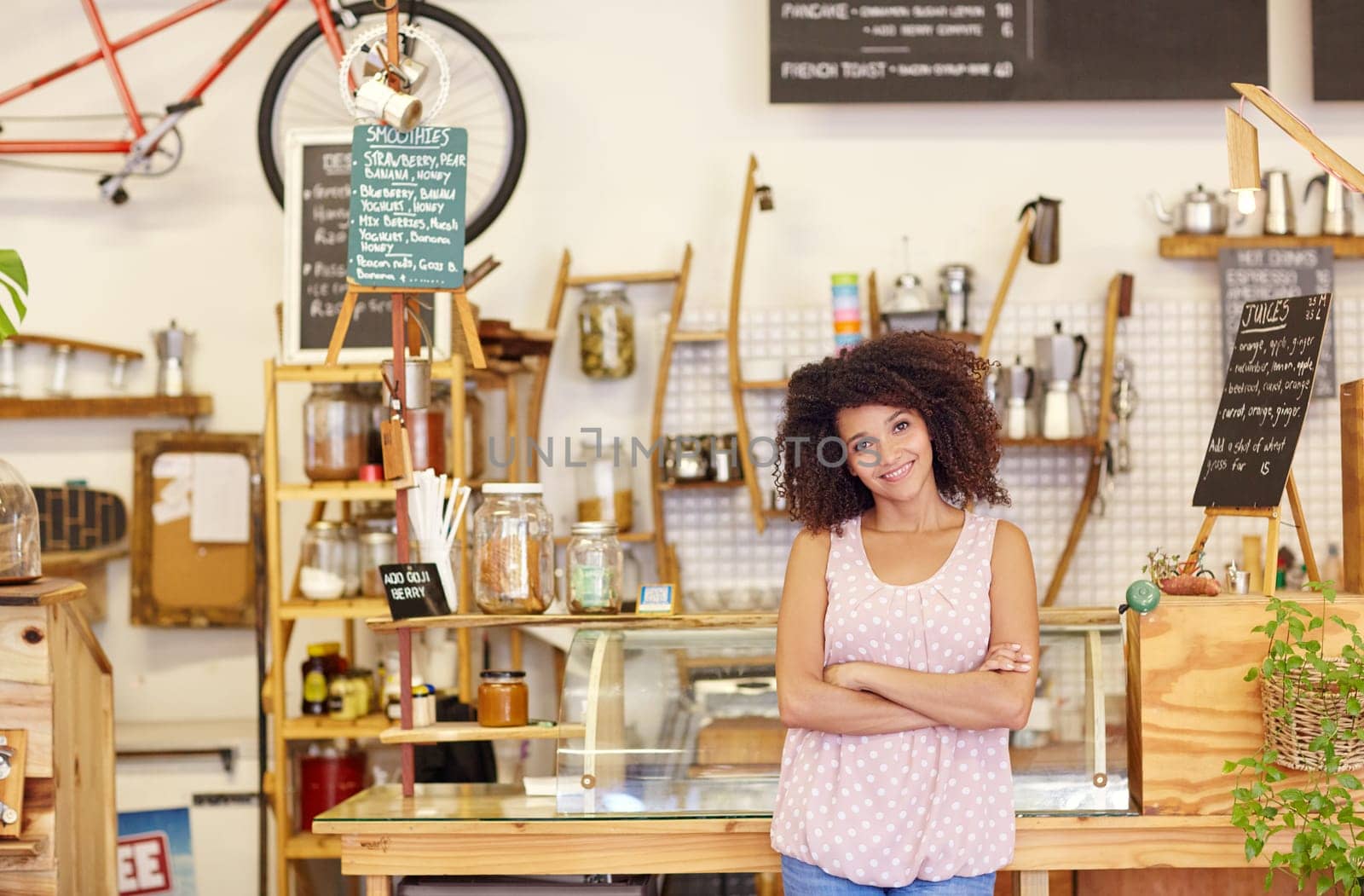 Young woman standing confidently in her coffee shop, proud of being a small business owner