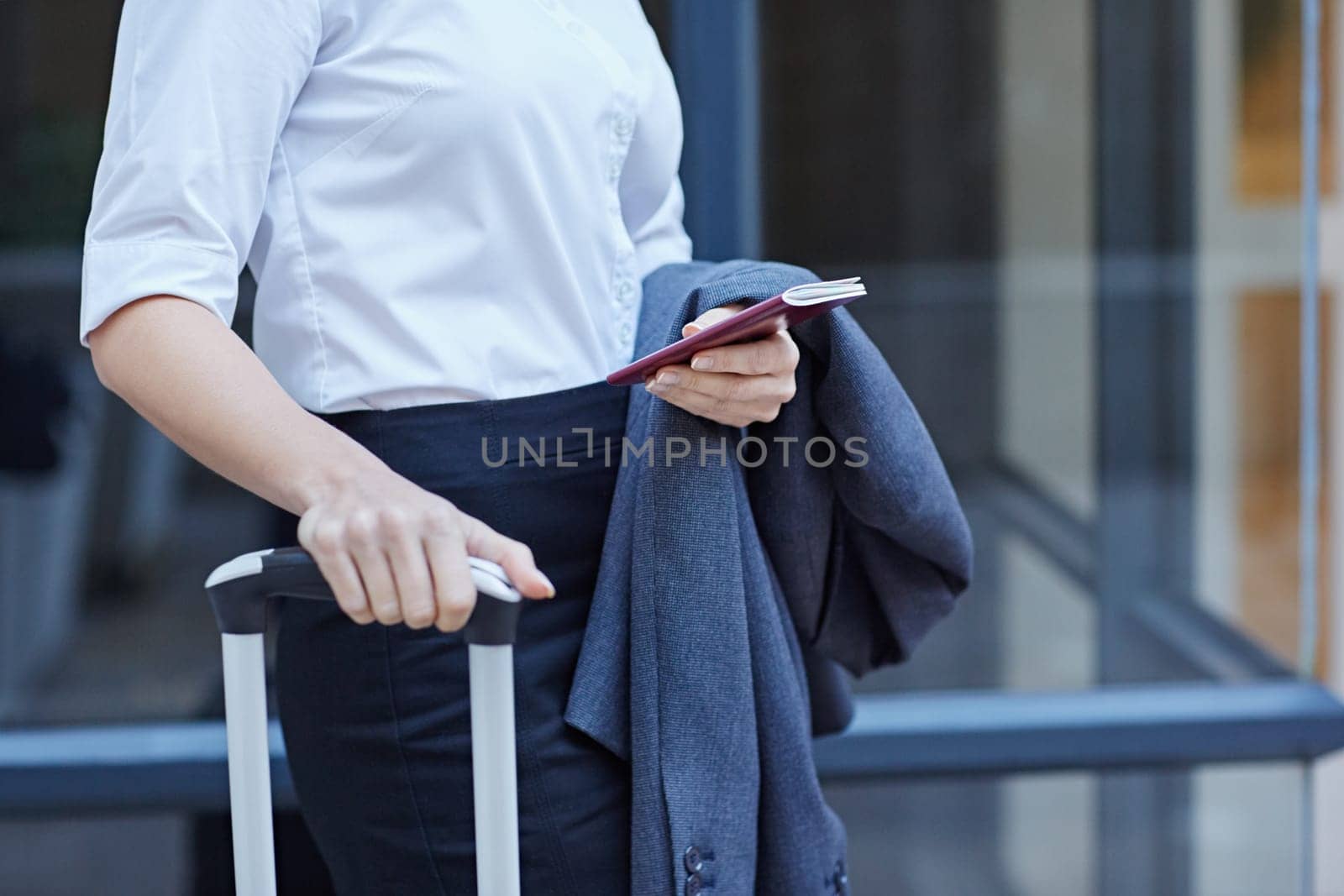 Cropped shot of a businesswoman with luggage and her passport