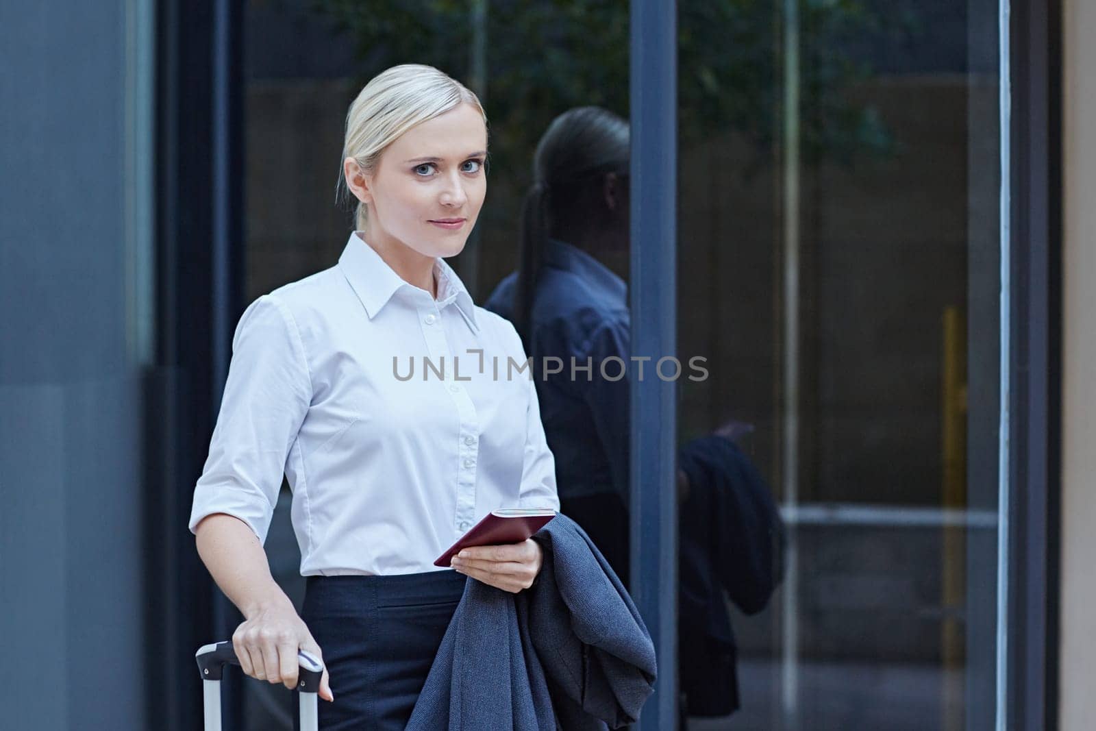 A young businesswoman walking with travel luggage