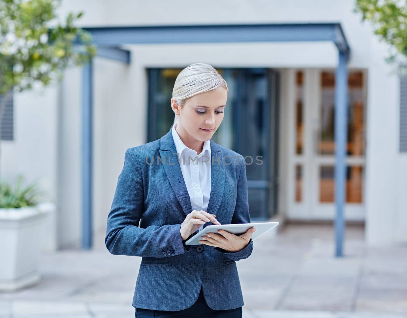 A young businesswoman working on her tablet outdoors