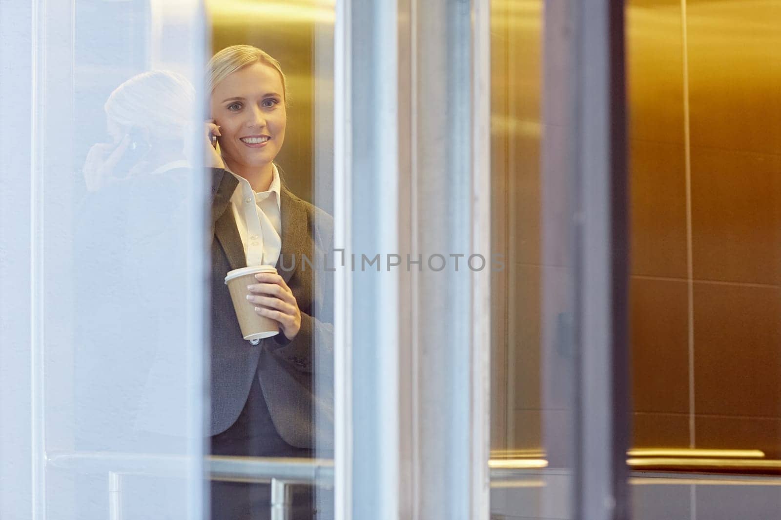 A young businesswoman talking on the phone in elevator