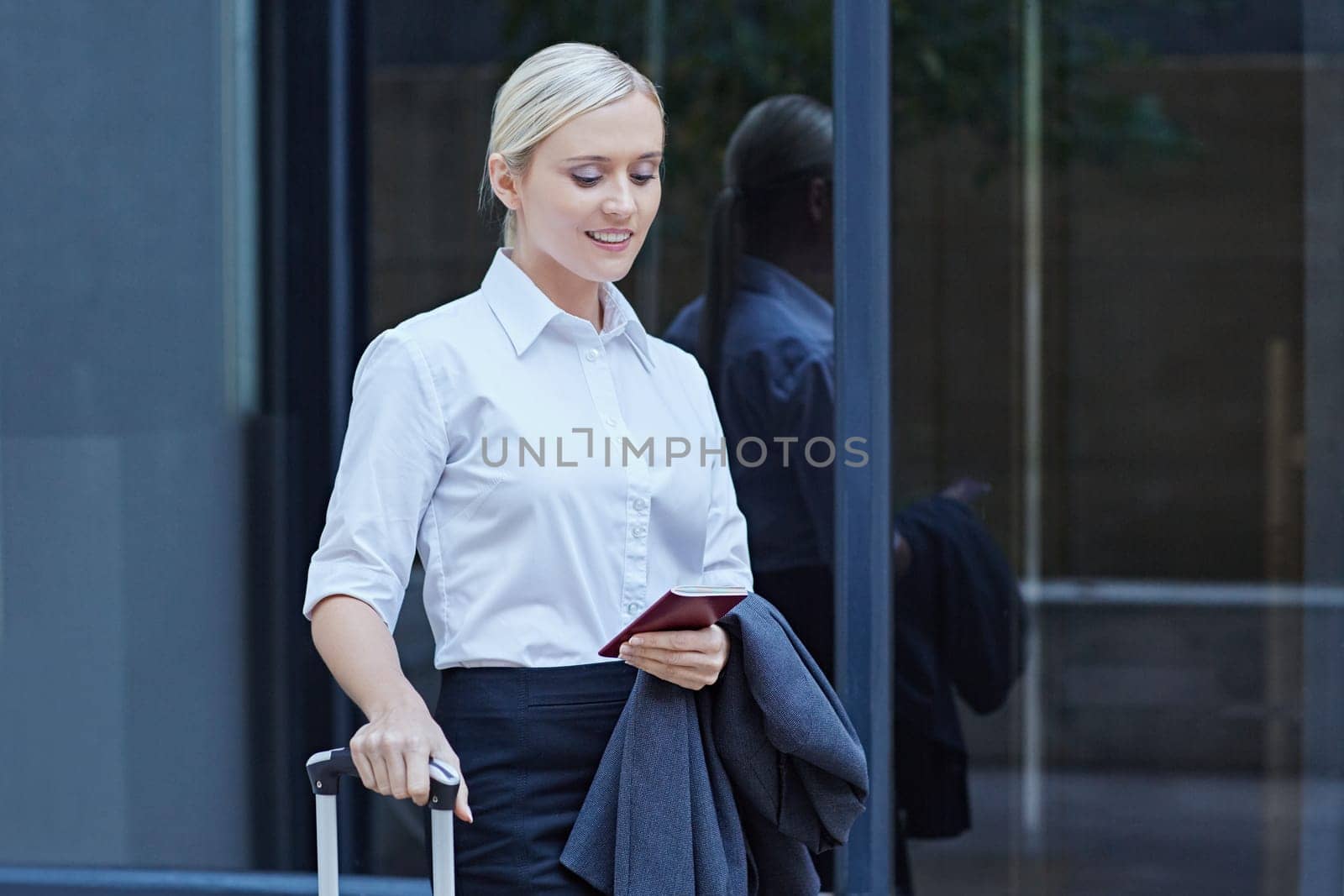 A young businesswoman walking with travel luggage