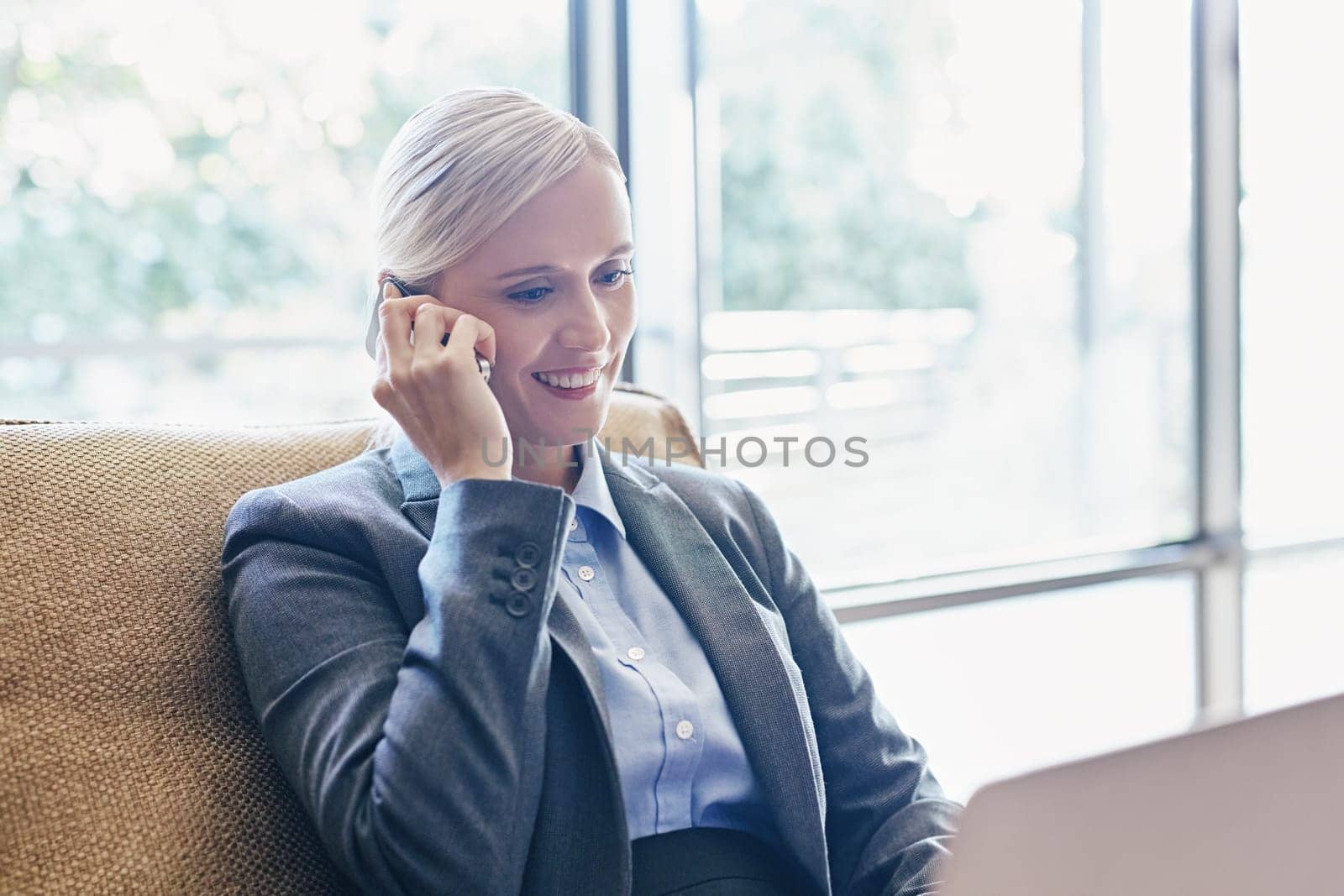 A young businesswoman working on her laptop while sitting on a sofa