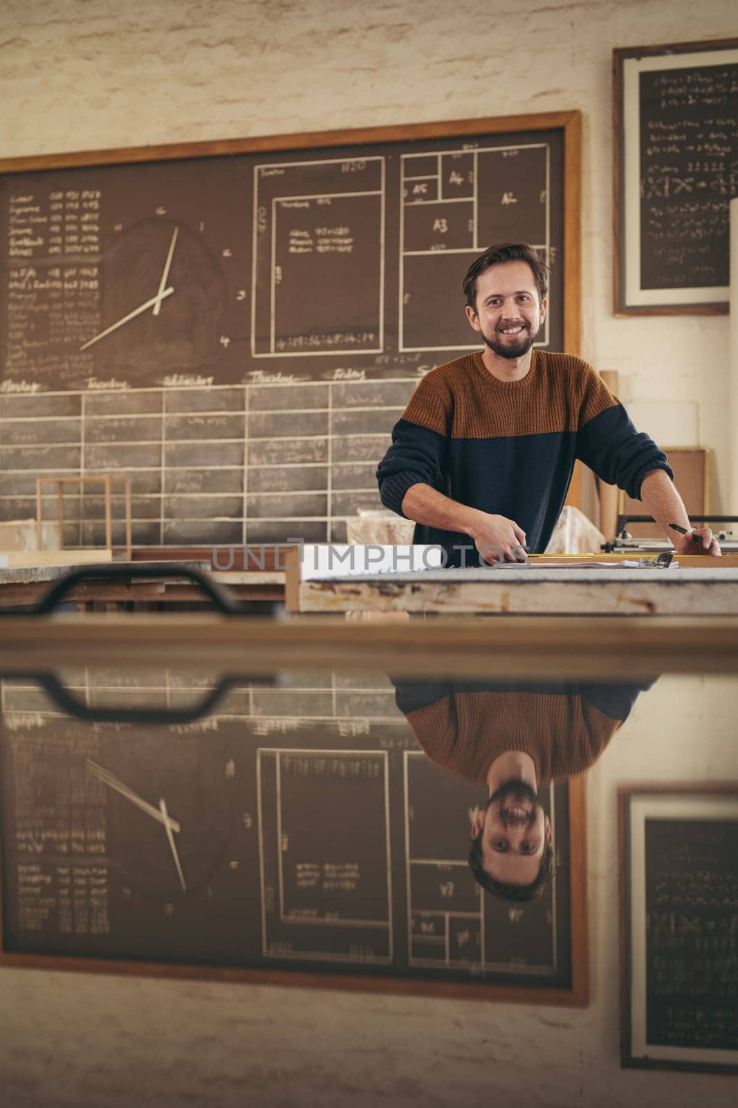 Portrait of a professional craftsman working in his studio on a project