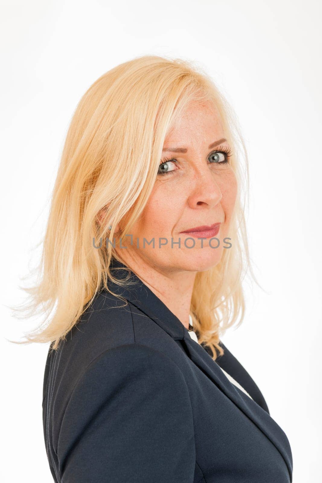 Side head-and-shoulder portrait of a middle-aged blonde woman in a dark blazer isolated on white.