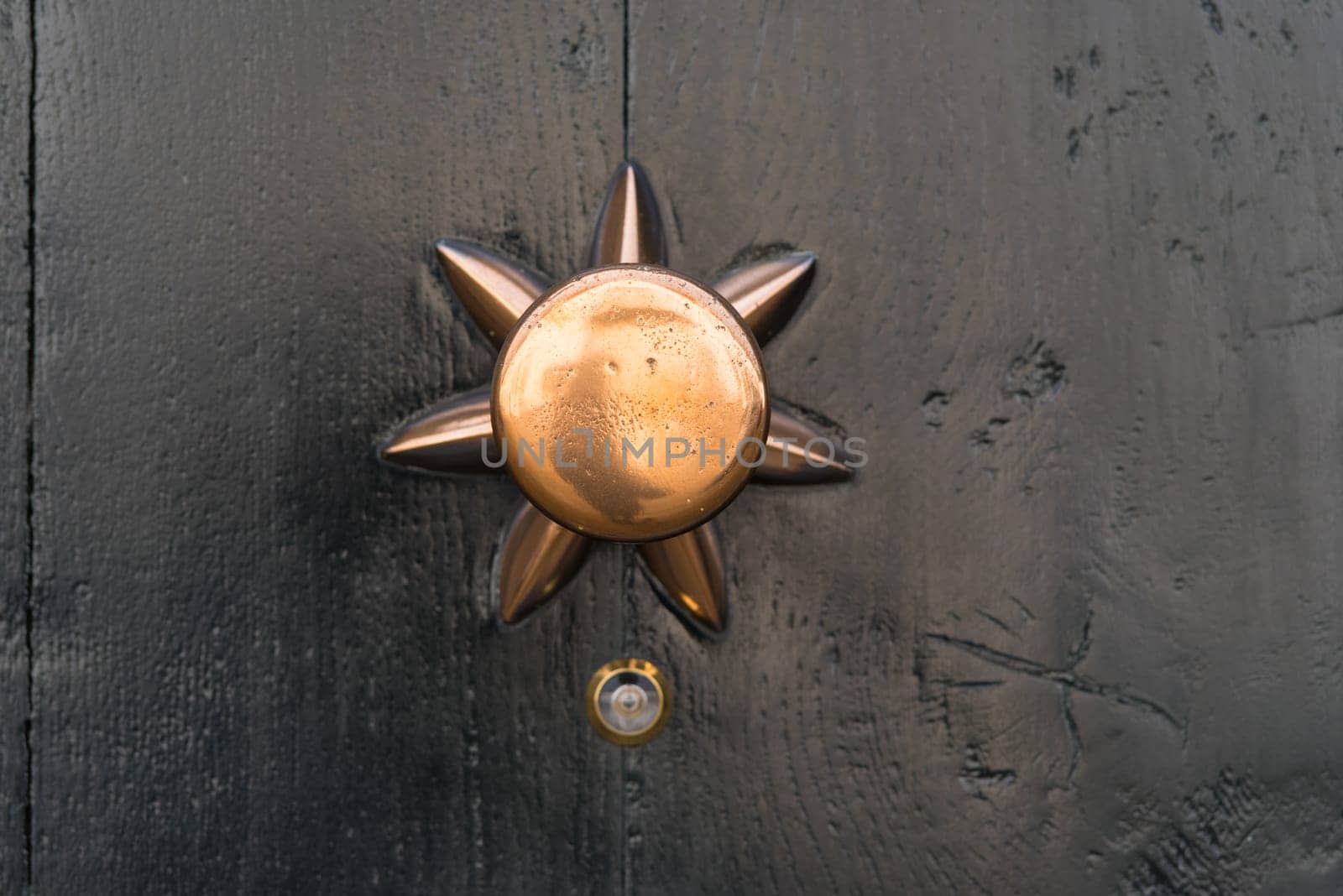closeup of a copper doorknob with a small peephole under it
