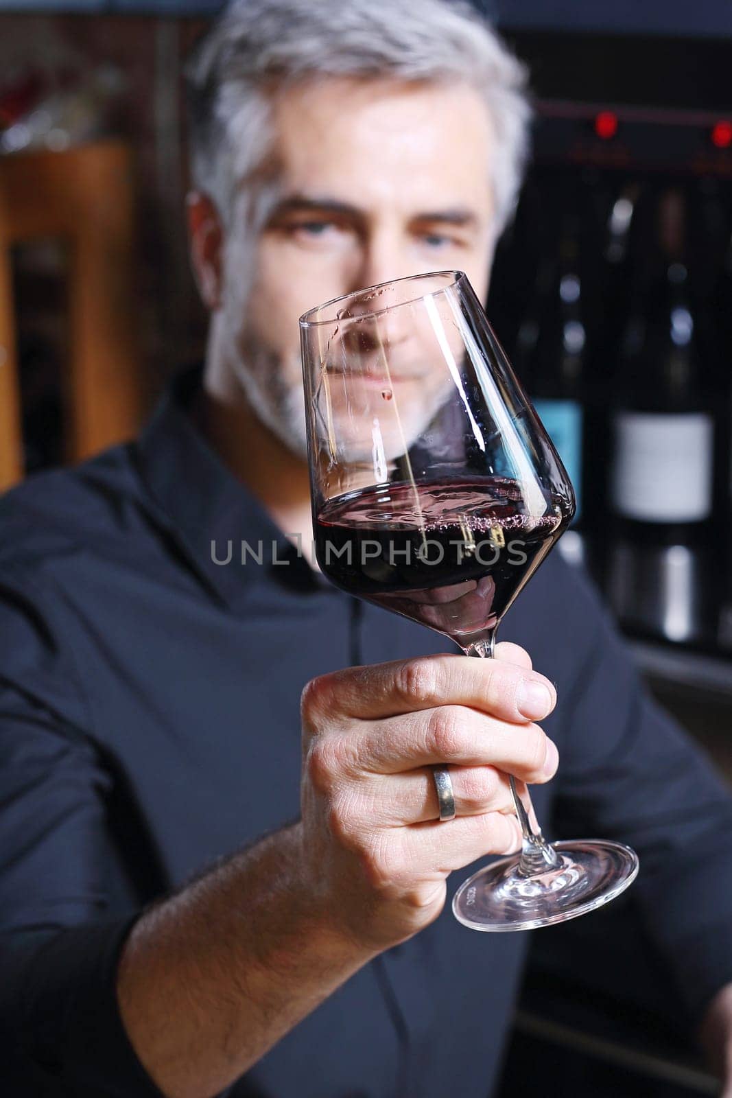 Man poured red wine into a glass. Sommelier selects wine.
