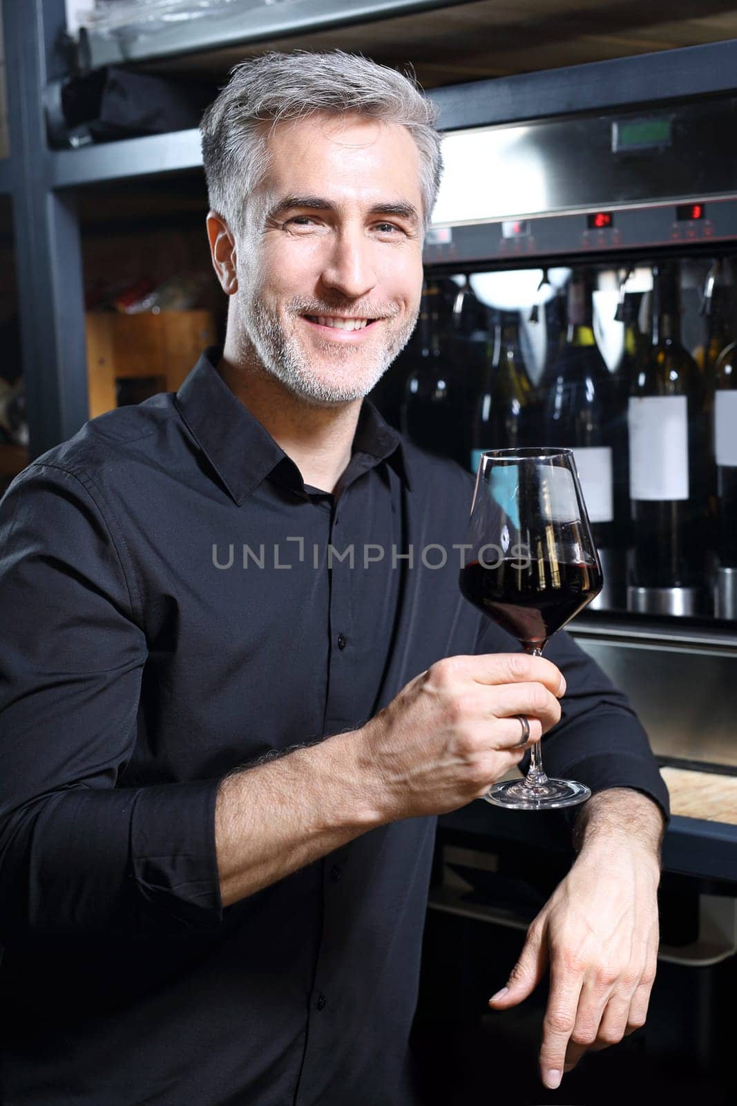 Man poured red wine into a glass. Sommelier selects wine.