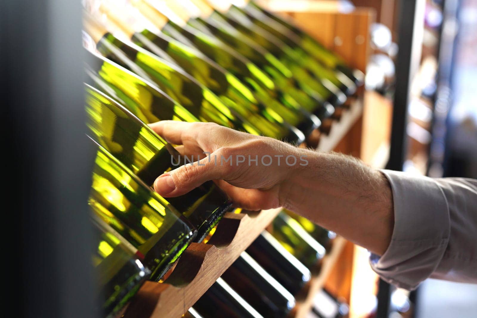 Wine. Man chooses a bottle of wine. Wine cellar