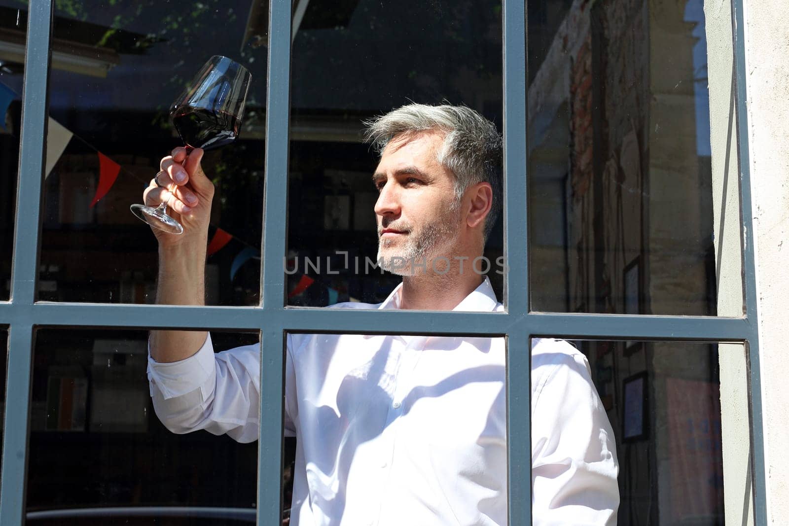 A glass of red wine. Handsome man drinking wine. Man drinking wine.