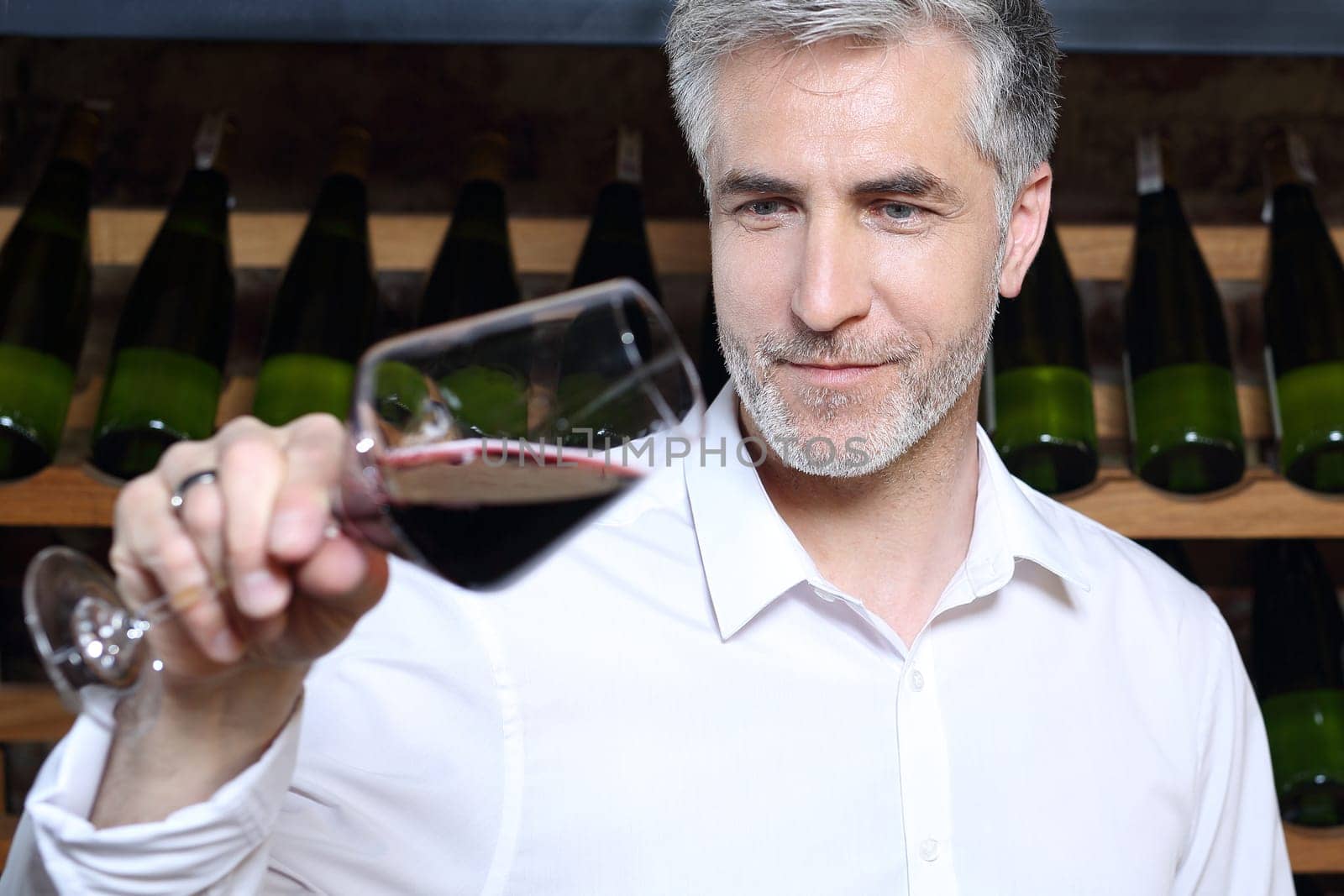 Man poured red wine into a glass. Sommelier selects wine.