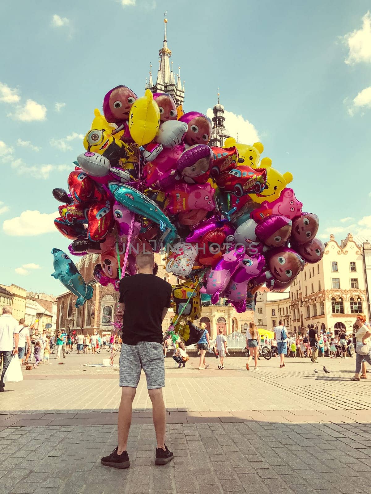 Krakow, Poland - July 29, 2017 : Male street vendor sells colorful popular cartoon character helium balloons