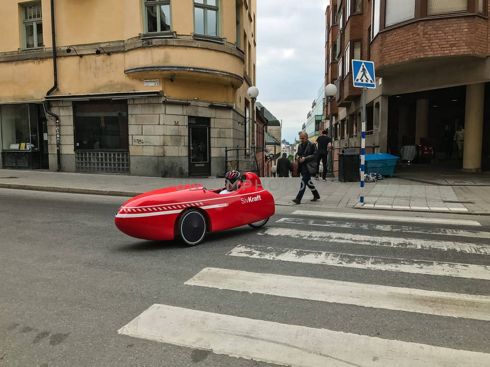 Oslo, Norway - 10 June 2017: Modern red Velomobile Mango Sport with driver in the old town
