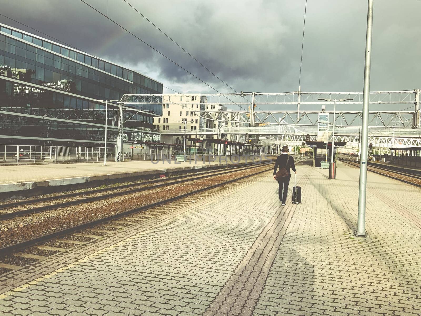 One businessman with luggage goes to the station, A man heading off on a business trip. Thunderstorm is coming