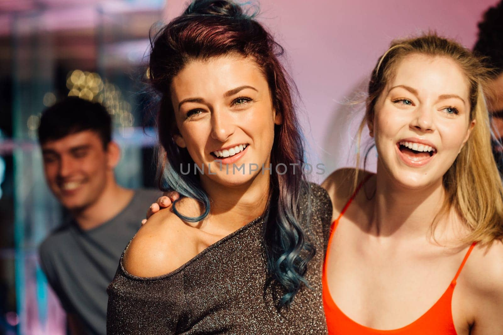 Happy women are dancing together in a nightclub.