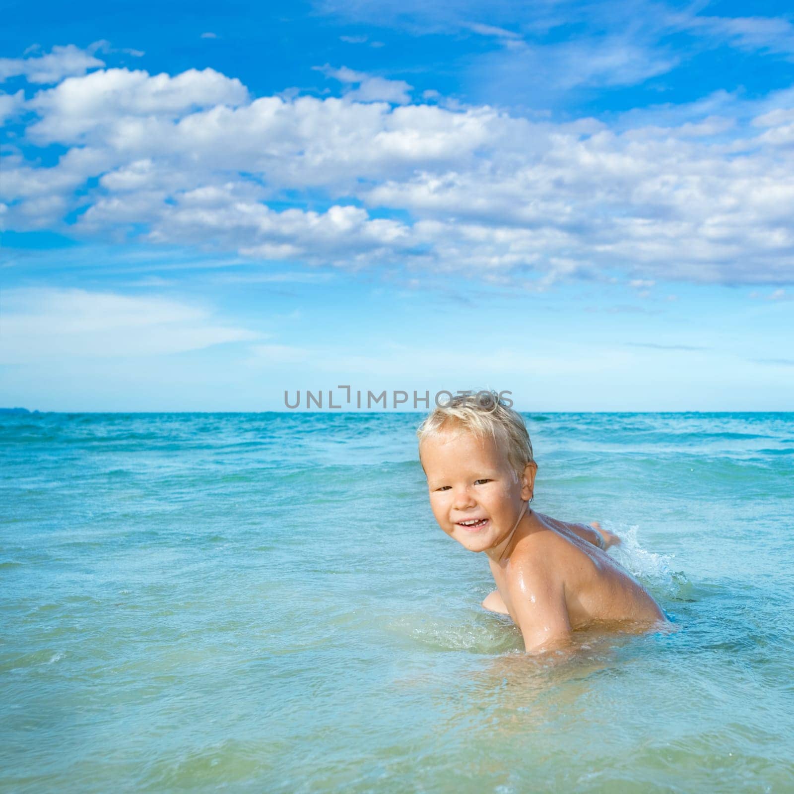 Cute boy plays in a sea