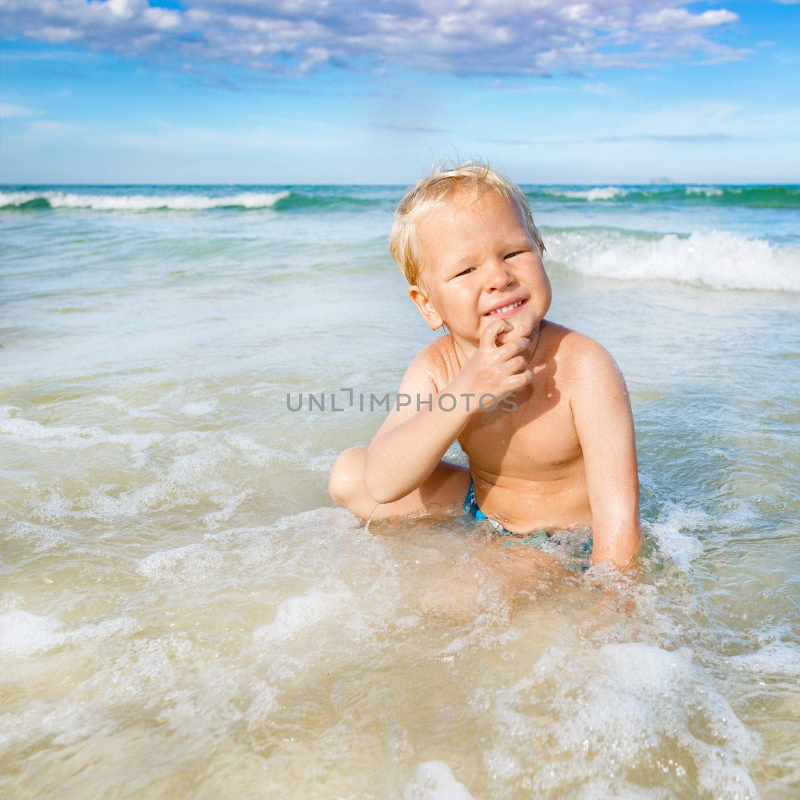 Cute boy plays in a sea