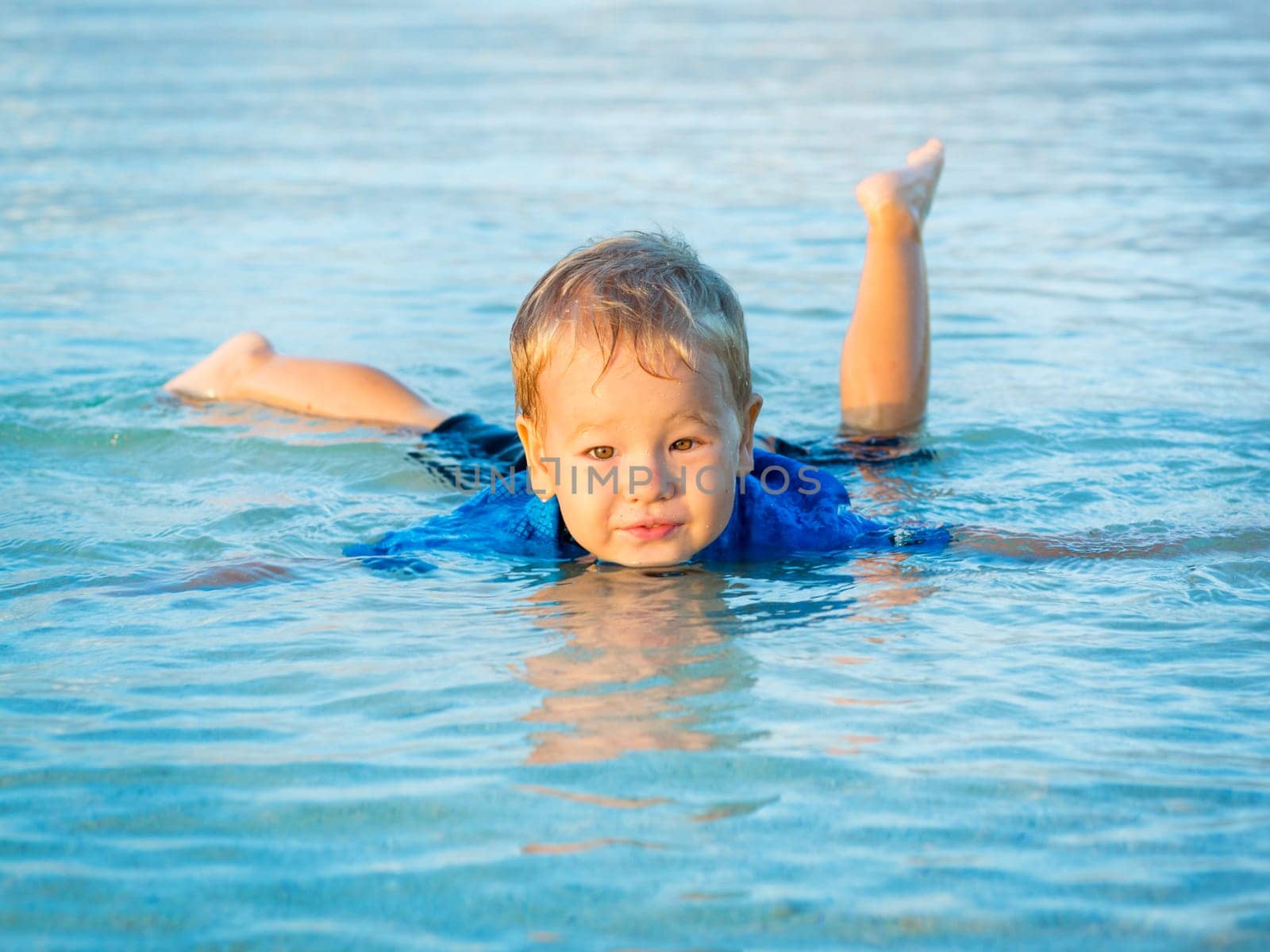 Cute boy plays in a sea