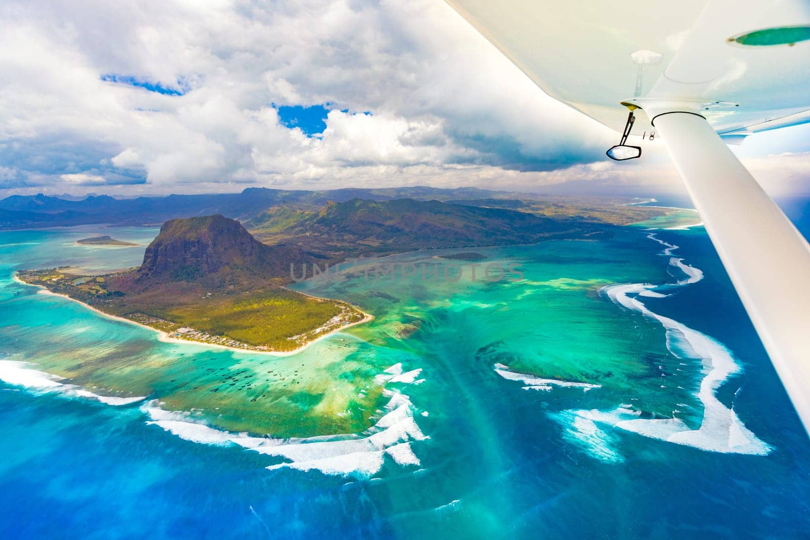 Aerial view of the underwater waterfall. Plane wing on the foreground. Mauritius