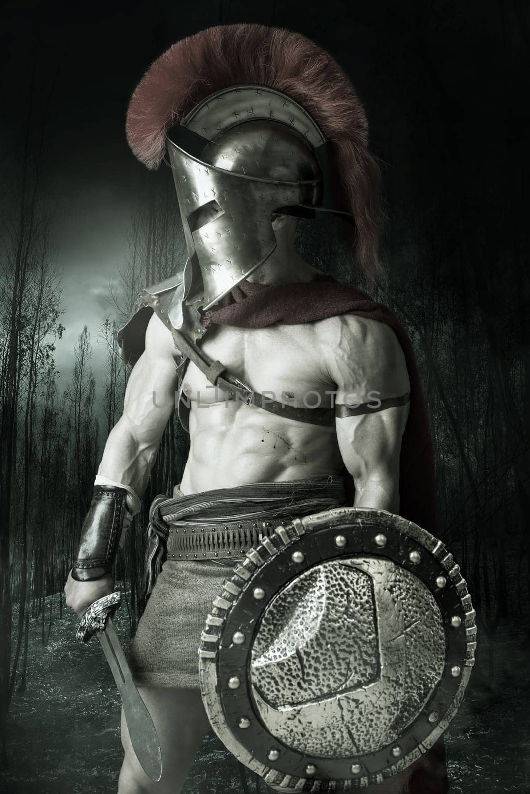 Ancient warrior or Gladiator posing in a dark forest
