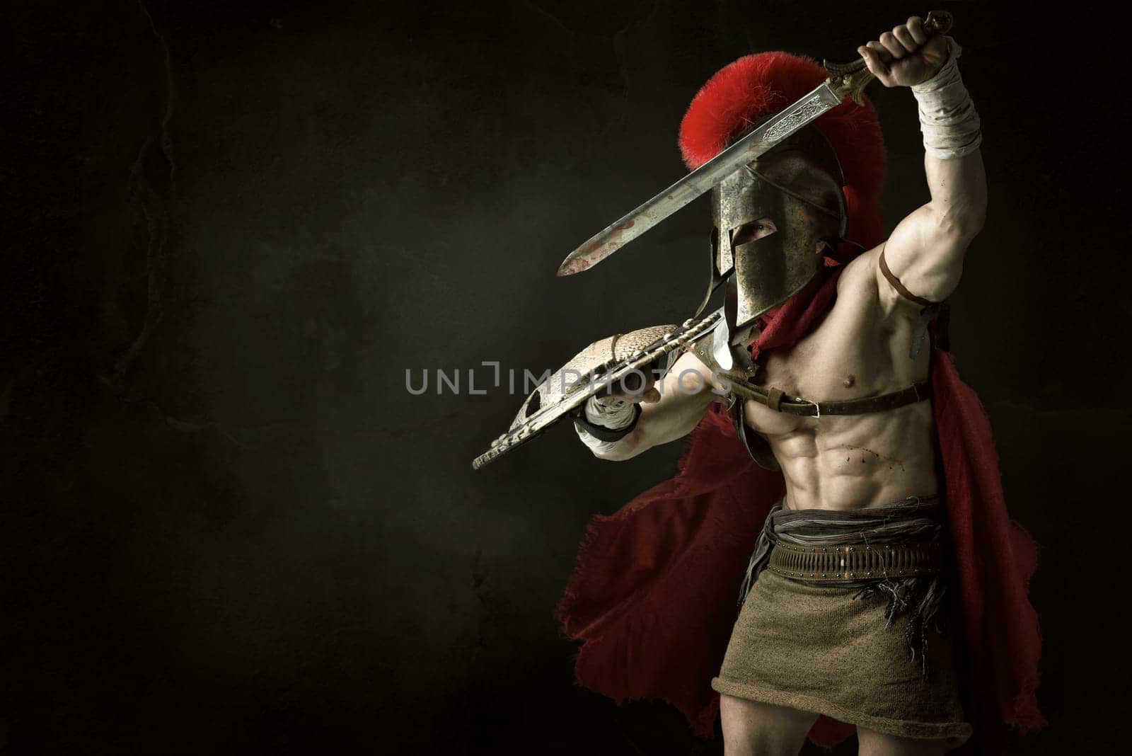 Ancient warrior or Gladiator posing over a dark background