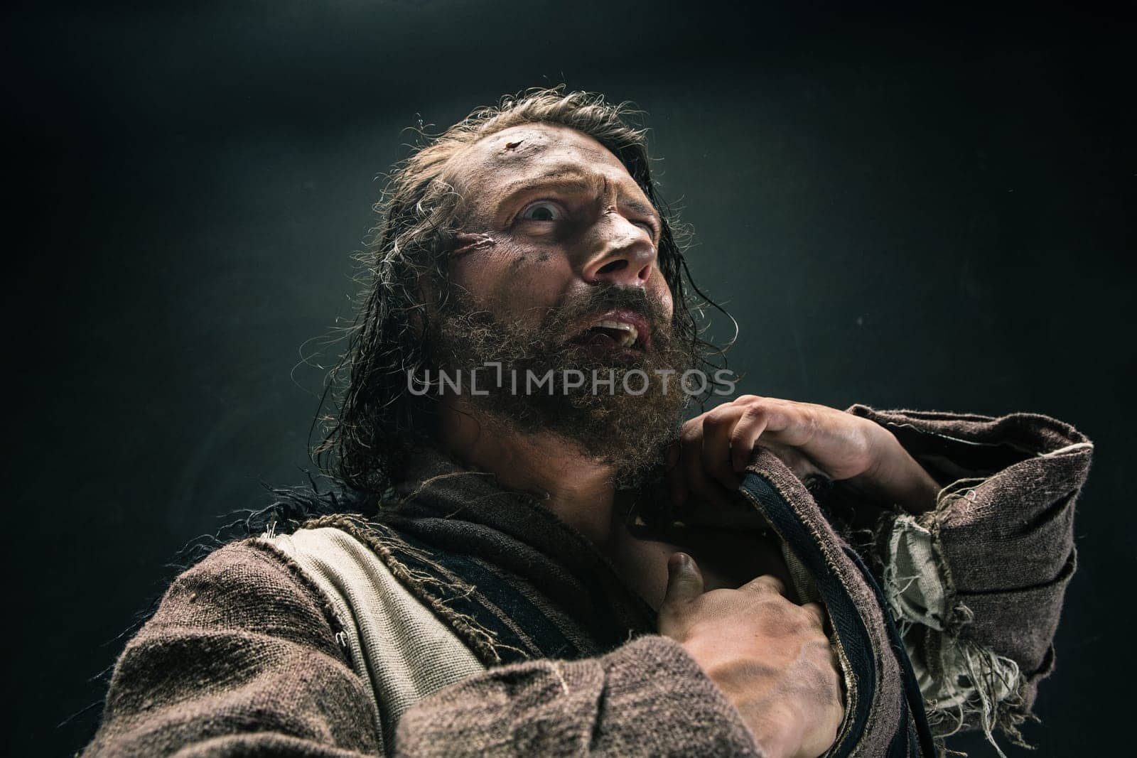 Portrait of a brutal bald-headed viking in a battle mail posing against a black background. Early medieval period.