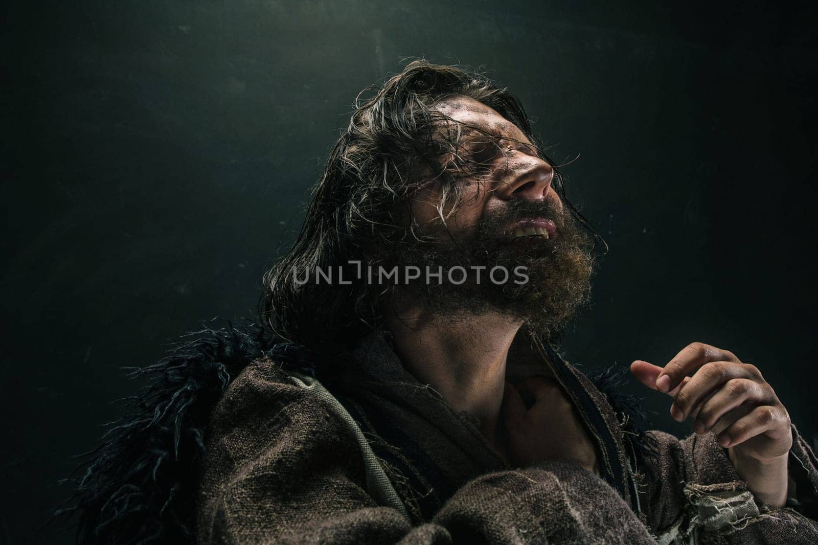 Portrait of a brutal bald-headed viking in a battle mail posing against a black background. Early medieval period.