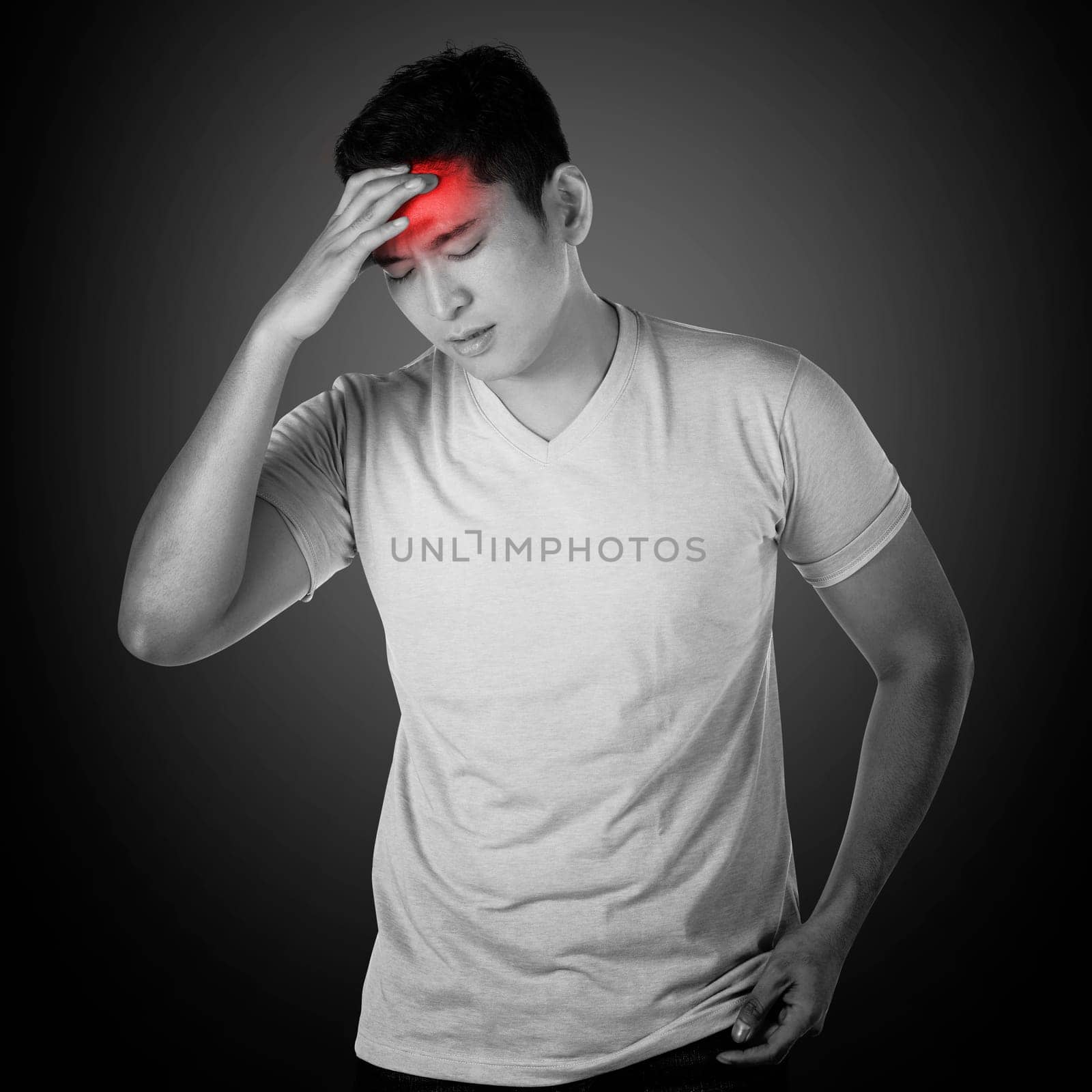 Asian man have headache. He touch his head with hand