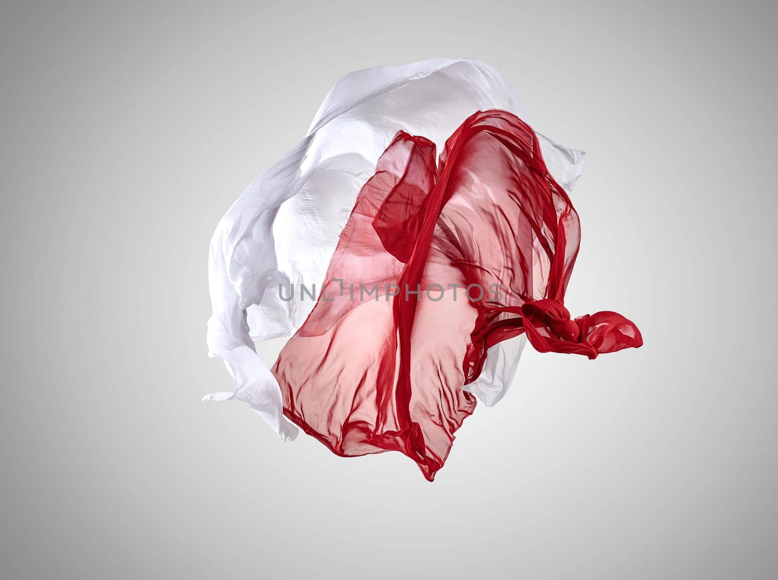 Smooth elegant transparent red and white cloth separated on gray background. Texture of flying fabric.