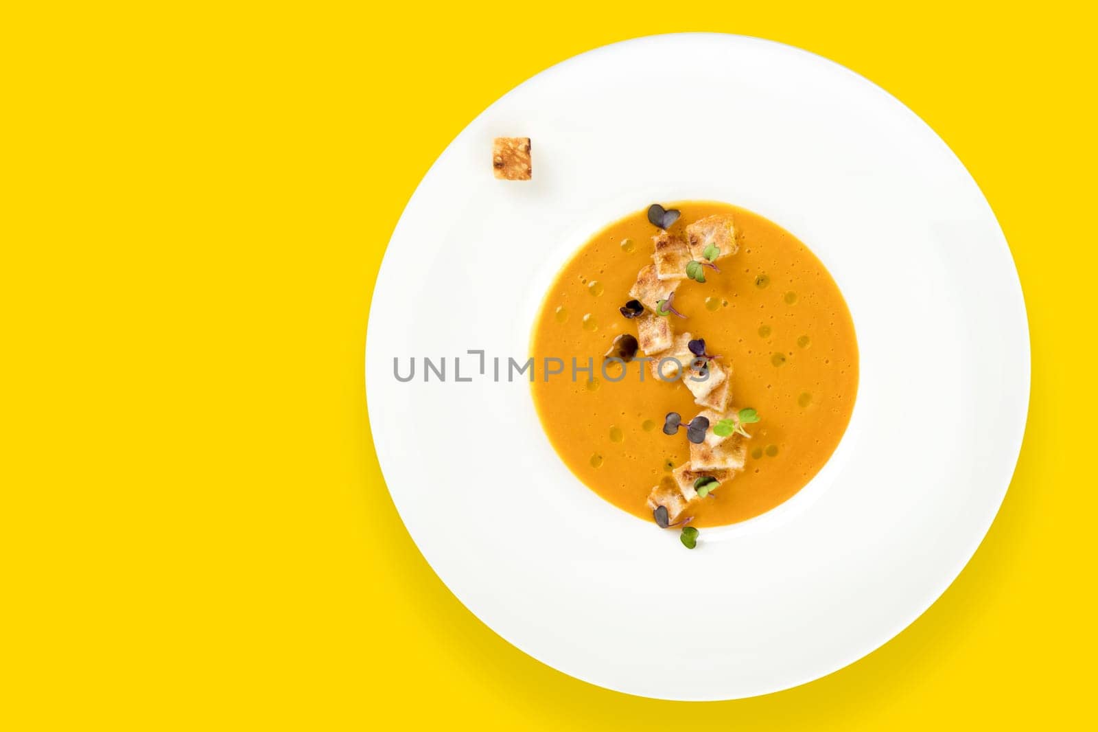 Vegetable soup with toast bread on yellow background