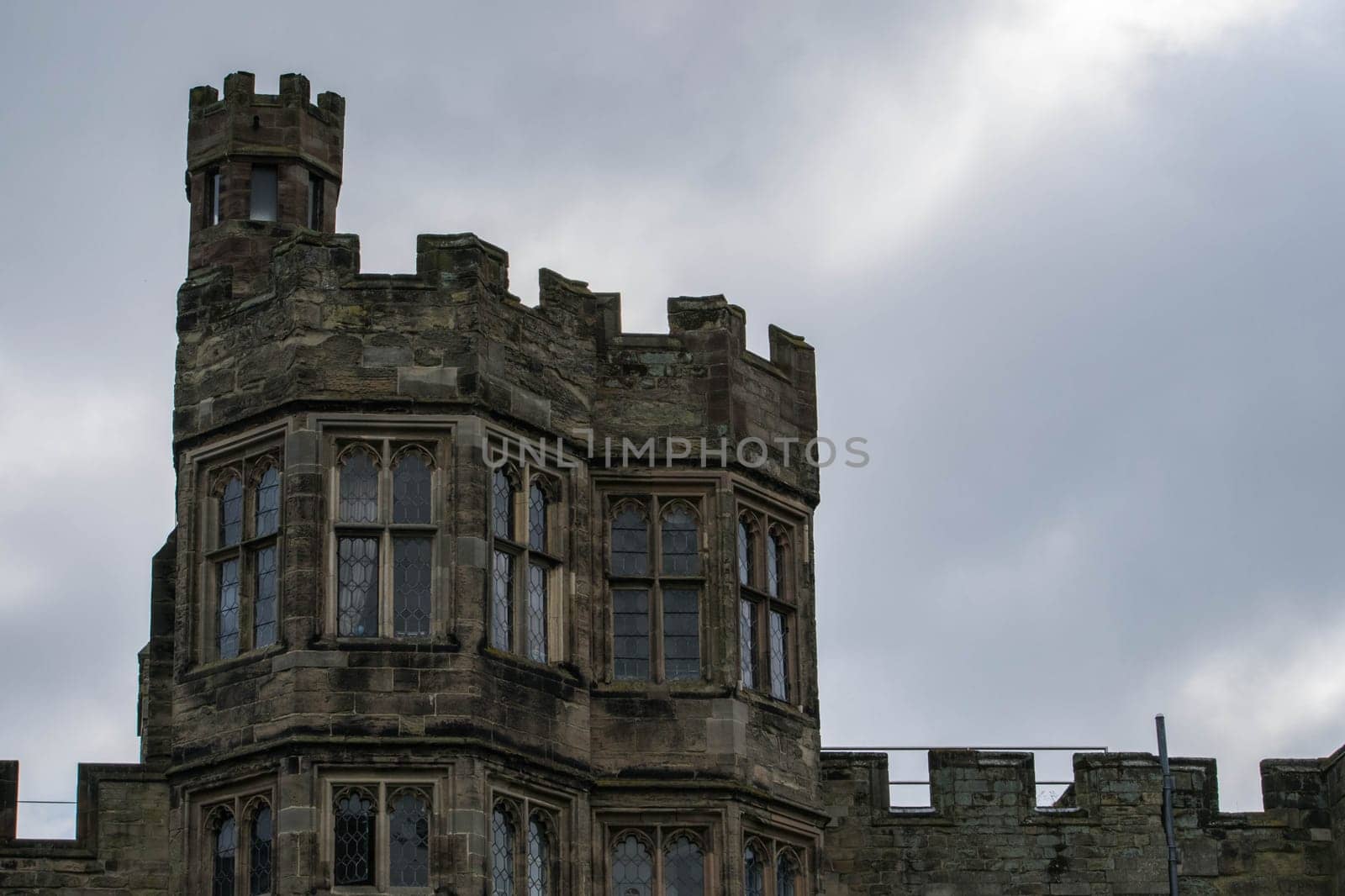 Warwick, United Kingdom - September 19, 2016: View of the Medieval castle tower and gatehouse from within the castle gardens and people enjoying the setting, Warwick, Warwickshire