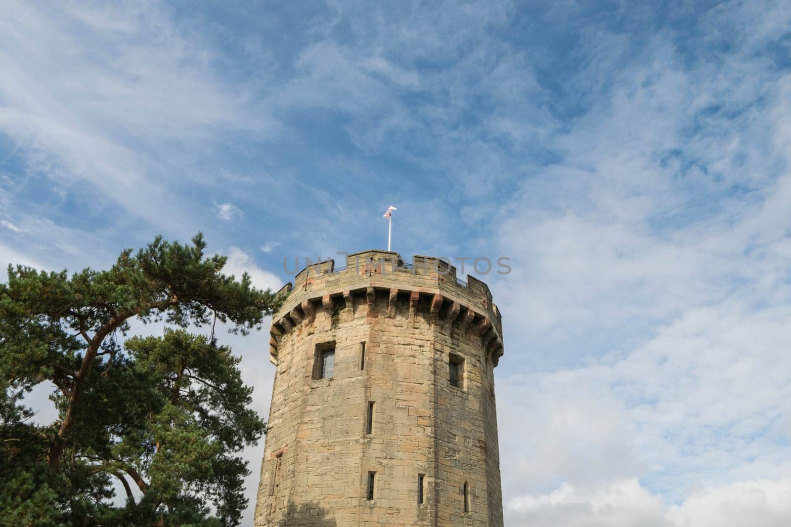 Warwick, United Kingdom - September 19, 2016: View of the Medieval castle tower and gatehouse from within the castle gardens and people enjoying the setting, Warwick, Warwickshire