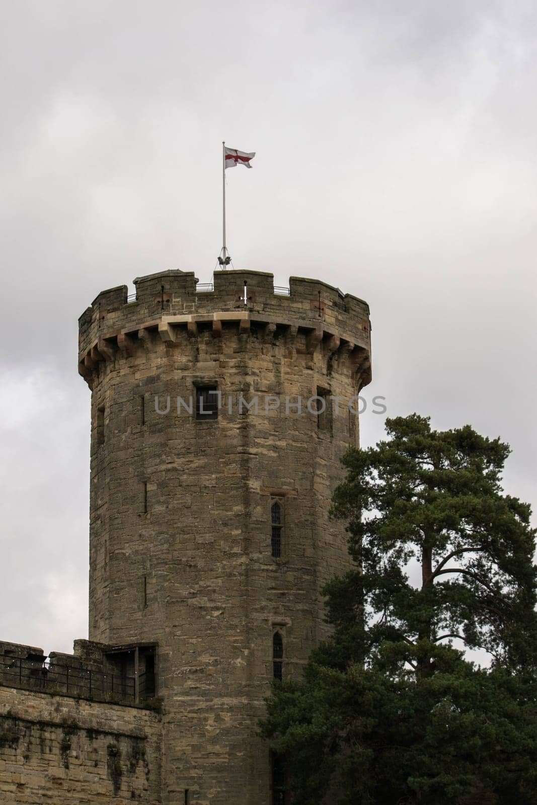 Warwick, United Kingdom - September 19, 2016: View of the Medieval castle tower and gatehouse from within the castle gardens and people enjoying the setting, Warwick, Warwickshire