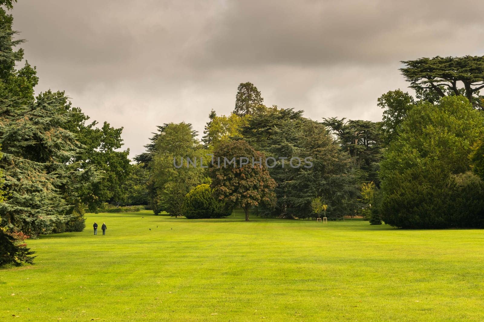 Warwick, United Kingdom - September 19, 2016: View of the Medieval castle tower and gatehouse from within the castle gardens and people enjoying the setting, Warwick, Warwickshire