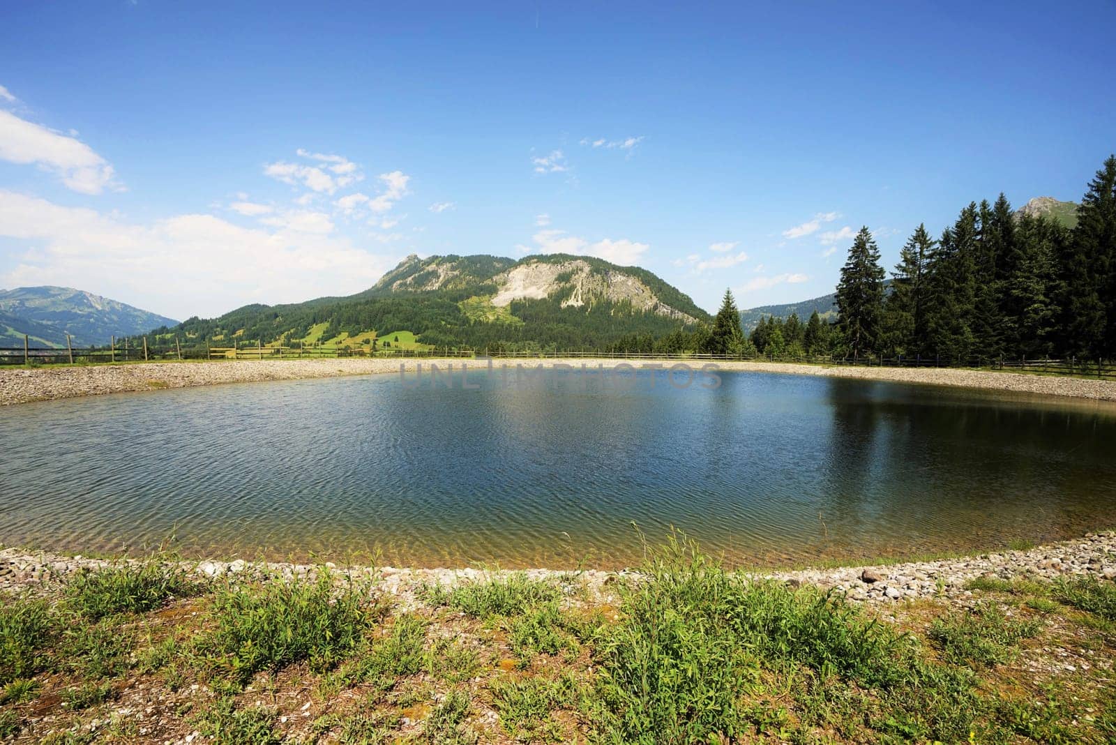 Alpine landscape in summer,in the foreground a storage pond